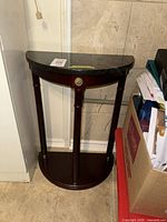 Full view of demilune table showing marble top, wood base, overall design