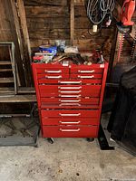 Full view of red 12-drawer tool cabinet on casters with items on top