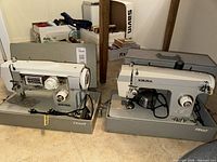 Two Viking sewing machines in hard cases