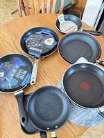 Overview of six fry pans and marble rotating organizer on table