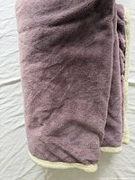 Folded blanket showing purple fleece exterior