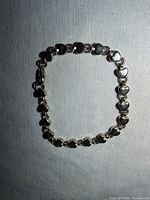 Front view of silver heart link bracelet laid flat
