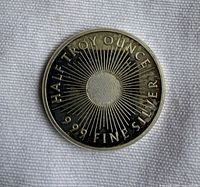 Obverse of silver round showing sunburst design and text