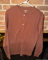Front view of brown J.Crew long sleeve Henley T-shirt hanging on hanger