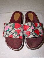 Top view showing both sandals, strawberry print GG canvas straps and burgundy monogram footbeds