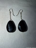 Front view of both earrings showing teardrop stones and chain drops