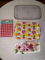 Overall view of three trays and packaged tablecloth on round surface