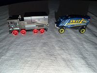 Front/side view of both toy trucks showing overall design and colours