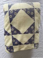 Folded cream and lavender daisy fleece blanket