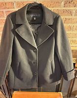 Front view of black pea coat on hanger