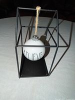 Full view of ornament hanging in metal house stand