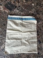 Front view of off-white cotton bag with patterned trim