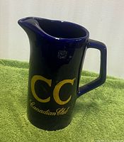 Front view of dark blue Canadian Club pitcher showing gold CC logo