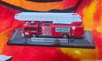 Front and side view of Hess miniature fire truck on display stand