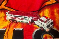 Left side view of Hess 2000 tiller firetruck toy showing cab, trailer and ladder