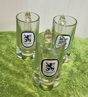 Front view of three Lowenbrau beer mugs showing logos