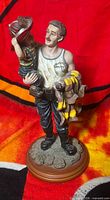 Front view of firefighter figurine holding child