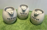 Front view of three VAT 69 Gold ceramic pitchers