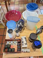 Overall view of lot on table including Denby bowl, pitchers, containers, OXO choppers, napkin rings, grinder and drinkware