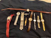 Group shot of all ten wristwatches laid out on black cloth