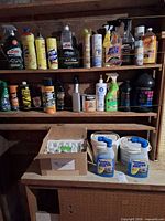 Shelves filled with assorted automotive and household cleaning products, jugs and pails visible