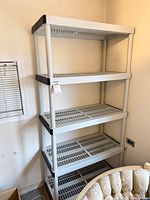 Full view of five-shelf plastic shelving unit against wall