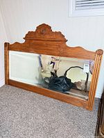 Full view of wood framed wall mirror resting against wall