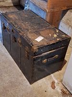 Overall view of closed metal trunk on floor