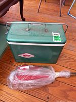 Front of green Coleman metal cooler, Canadian flags bundle visible