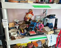 Shelves showing flashlights, lantern, drink cups, keychains, coasters, scarecrow and assorted small items