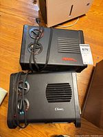 Two black space heaters side by side showing top control dials and branding