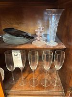 Shelf with 5 champagne flutes, etched vase, pink candlesticks, slumped bottle dish on plates
