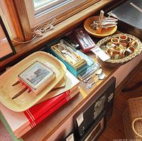 Overall lot showing spoons, boxed cutlery, teak napkin rings in basket, placemats