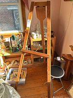 front view of oak-stained wooden A-frame floor easel with support bar