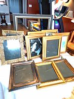 Stack and grouping of assorted gold and black frames front view
