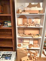 Shelved assortment of unfinished pine pieces including word sign, silhouettes, plaques, trays, frames, small boxes