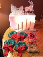 Overall lot view showing sleigh, reindeer, candelabra illuminated, six fabric door-knob hangers