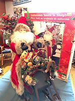 Front view of Santa figure in decorated sleigh with box in background