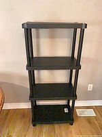 Overall view of black plastic 4-shelf unit