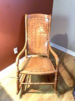 Front view of wooden rocking chair showing perforated design