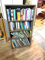 Front view of brown three-shelf bookcase filled with books