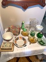 Full lot overview on table showing variety of glass and ceramic items
