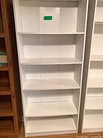 Front view of white 5-shelf bookcase showing all shelves and back panel