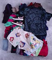 Pile showing dresses, sweaters, Nike shoes, Mexican tee, custom shorts