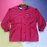 Full front view of red Tommy Hilfiger windbreaker jacket on color backdrop