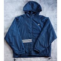 Front view of navy Adidas hooded jacket showing logo and stripe detail