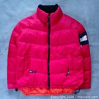 Front view of red Tommy Hilfiger puffer jacket showing overall design, zipper, pockets