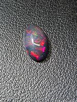 Front view of oval Ethiopian black opal showing multicolored play-of-color