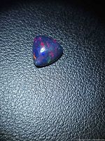 Top view of the Ethiopian black opal trillion cabochon showing multicolour play of colour