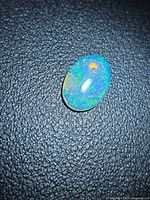 Front view of oval Ethiopian opal showing multicolored pinfire pattern